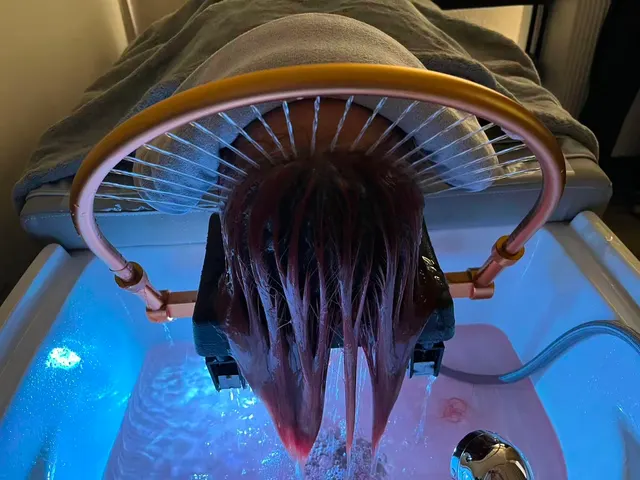 Hair fanned through the gold waterfall arch over a blue-lit basin during a head spa at O2 Head & Beauty Spa in Arcadia