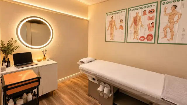 Pain relief massage room at Oxygen Head & Beauty Spa in Arcadia, with a treatment bed and meridian charts