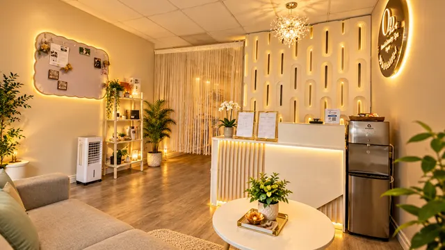 Warmly lit reception with a white desk, seating and chandelier